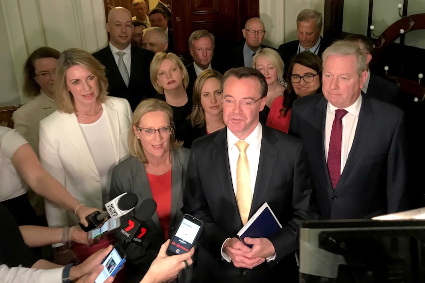 Michael O'Brien surrounded by Liberal MPs at a press conference.