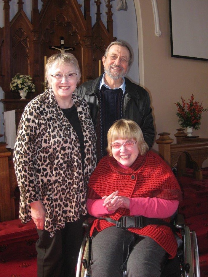 Coral and Tony Gallasch stand behind their daughter Amy during a recent visit to church