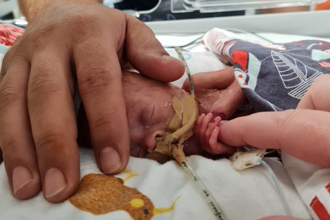 Levi Atkinson with parents' hands