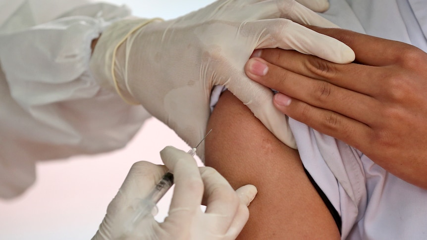 A medical worker gives a vaccine shot 