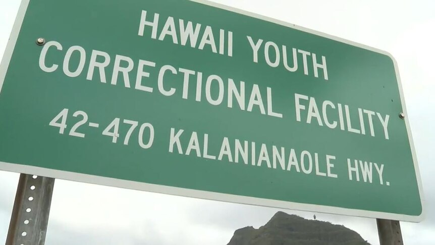 Green road sign with white writing saying 'Hawaii Youth Correctional Facility' 42-470 Kalanianaole Hwy'.