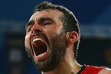 A Perth Wildcats NBL player screams out as he celebrates during a game.