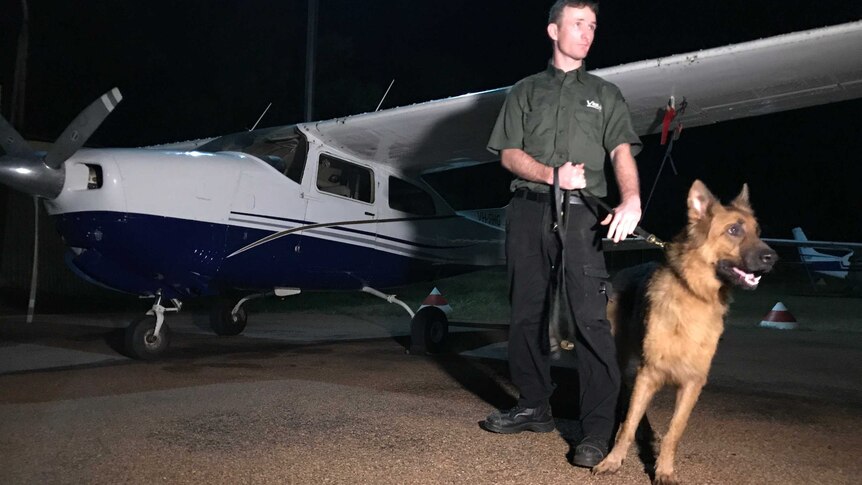 A security guard stands with a dog in Galiwin'ku.