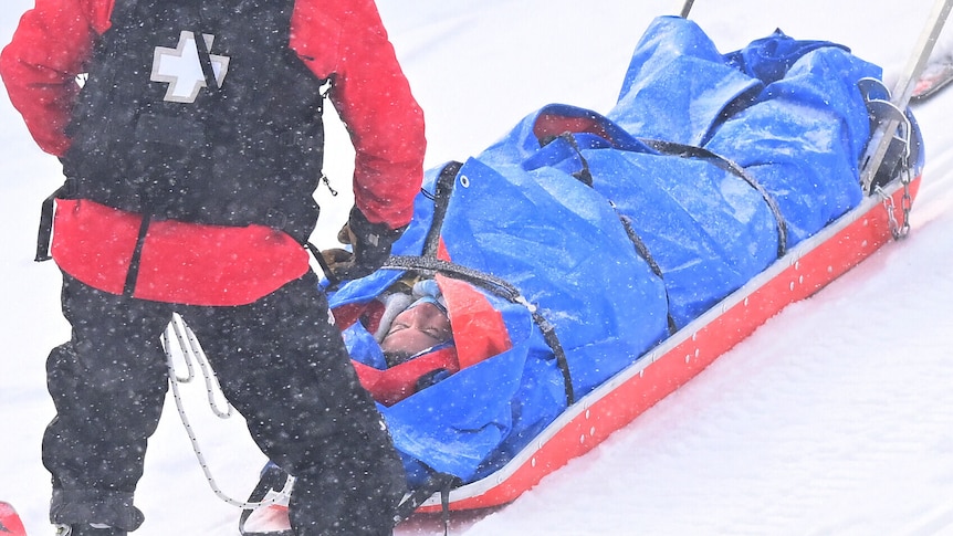 An Australian snowboard cross athlete on a stretcher at the Beijing Winter Olympics.
