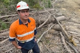 Dave White in a hard hat and high visibility clothing in a forest.