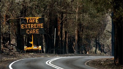 A temporary road sign erected among the charred landscape on the road into Kinglake