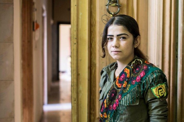 An Arab girl, a female member of the internal security forces waits outside the house to accompany Manjib's female co-president