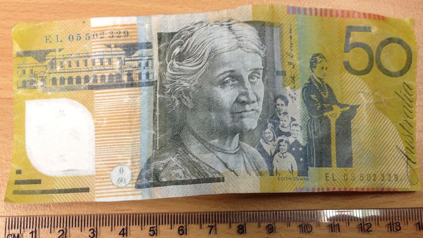 A Fake 50 dollar note above a ruler