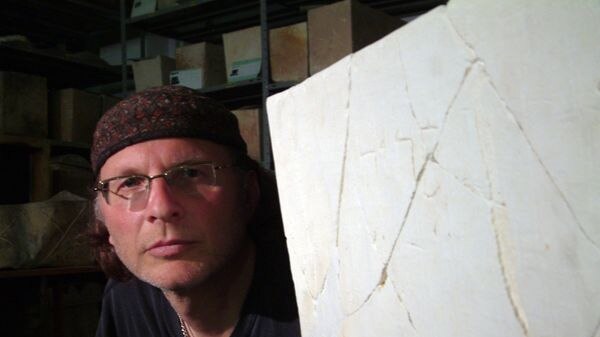 Canadian filmmaker Simcha Jacobovici poses beside a burial box discovered inside a cave in Jerusalem.