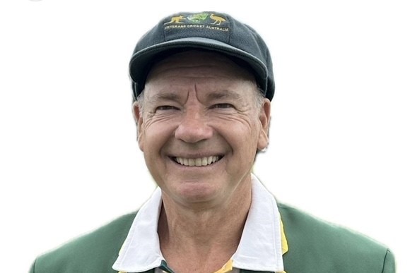 Peter Jensen wears a baggy green hat and green blazer while smiling.