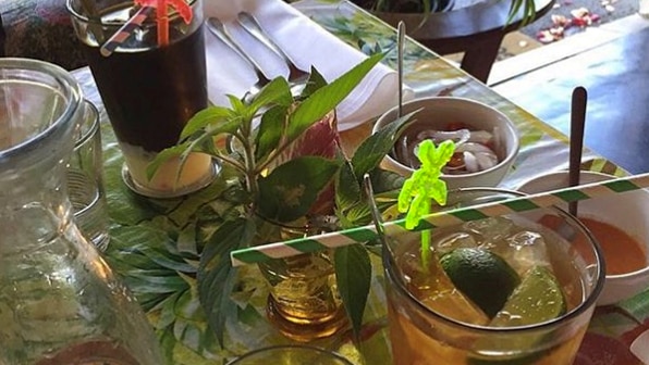 Tropical drinks and sambal in small bowls set on table in restaurant.