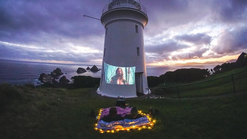 Picture of a movie projected onto a lighthouse