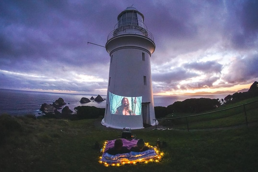 Picture of a movie projected onto a lighthouse