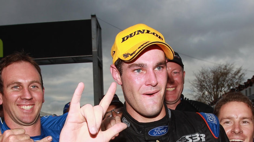First V8 win... Shane van Gisbergen salutes after taking the chequered flag in Hamilton.