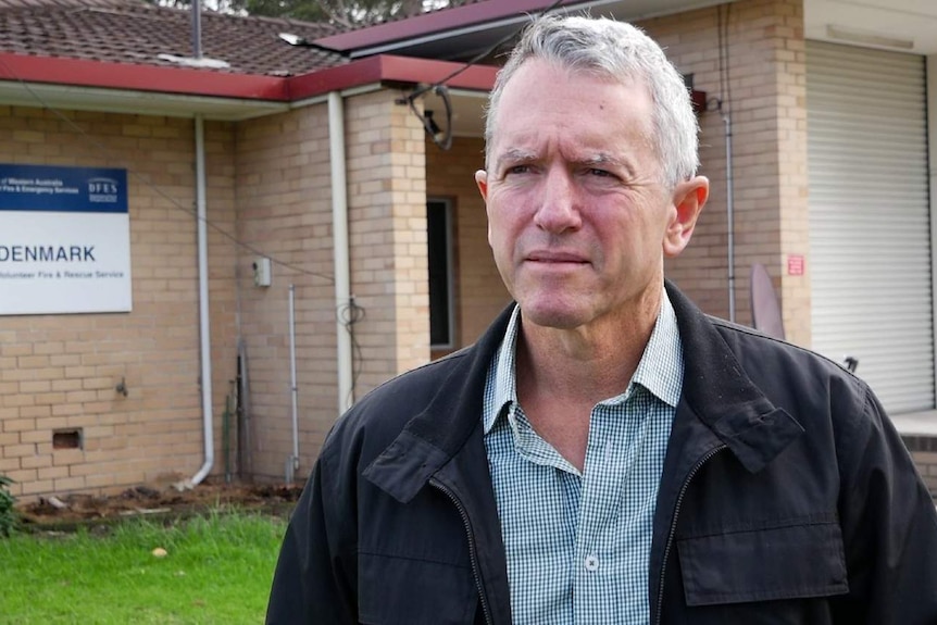 Terry Redman standing in front of a fire station.