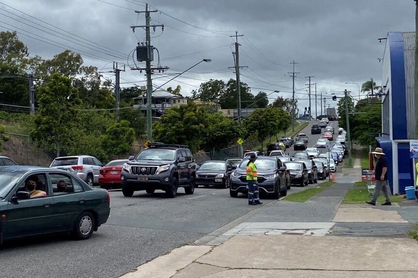 Cars line up for COVID test on Newmarket Road at Wilston.