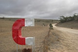 A large magnet symbol that is red and white on the edge of Magnetic Hill., a tourist attraction at Orroroo SA