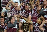 Victory is sweet ... Manly players celebrate with the premiership trophy after escaping the Warriors.
