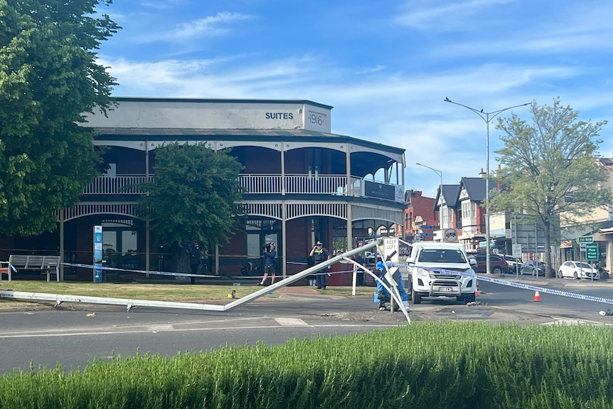 A fallen street light outside a country pub beneath a sunny sky.