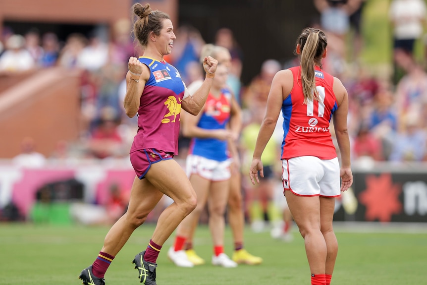 A Brisbane Lions AFLW player pumps her fists as she celebrates a goal in the grand final against Melbourne.