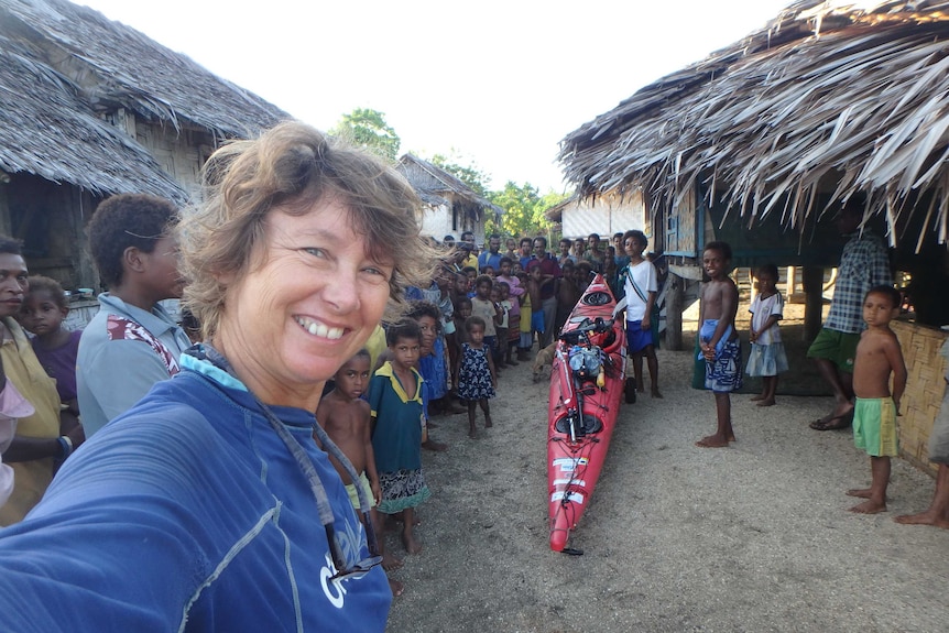 Sandy Robson snaps a selfie with the residents of a Papua New Guinean village she has been invited to stay in overnight.