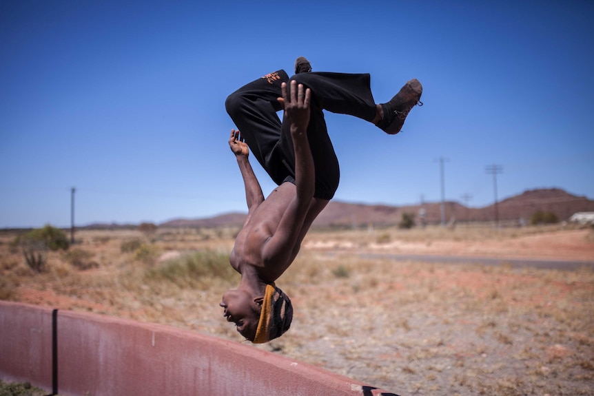 A young boy does a backflip in the remote community of Blackstone, WA.