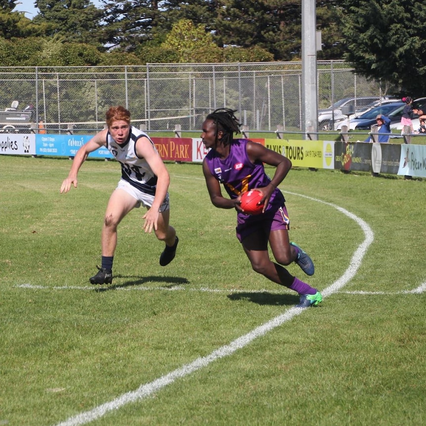 Two men play AFL football