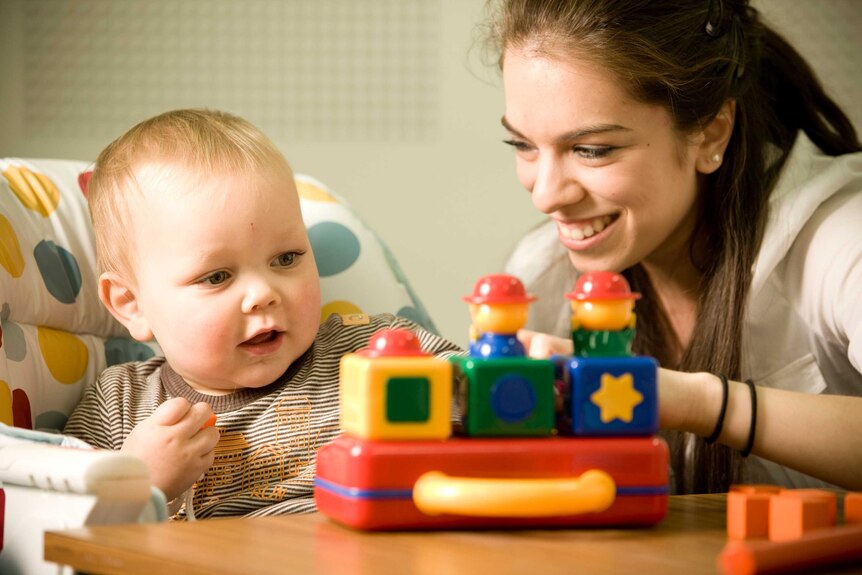 Genevieve and her son Henry playing with colourful building blocks.
