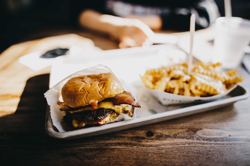 A hamburger and chips on a tray