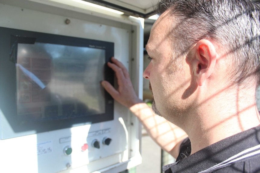 Peter Dobra checks the reading on a quick-dry machine on his family's lettuce farm.