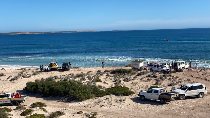 Emergency service and other vehicles at a beach.