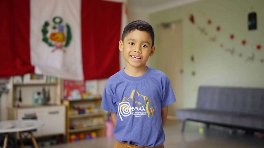 Child standing with Peru flag in the background