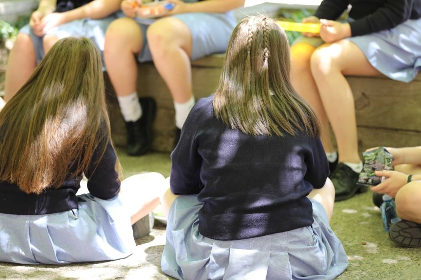 Niñas de la escuela sentadas en uniforme