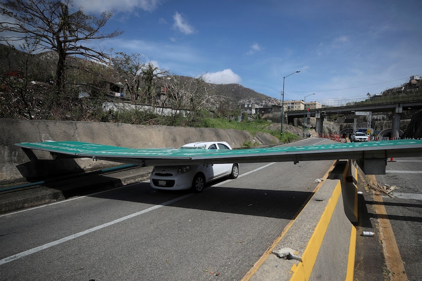 A street sign that has fallen on a car is pictured in the aftermath of Hurricane Otis in Acapulco. 