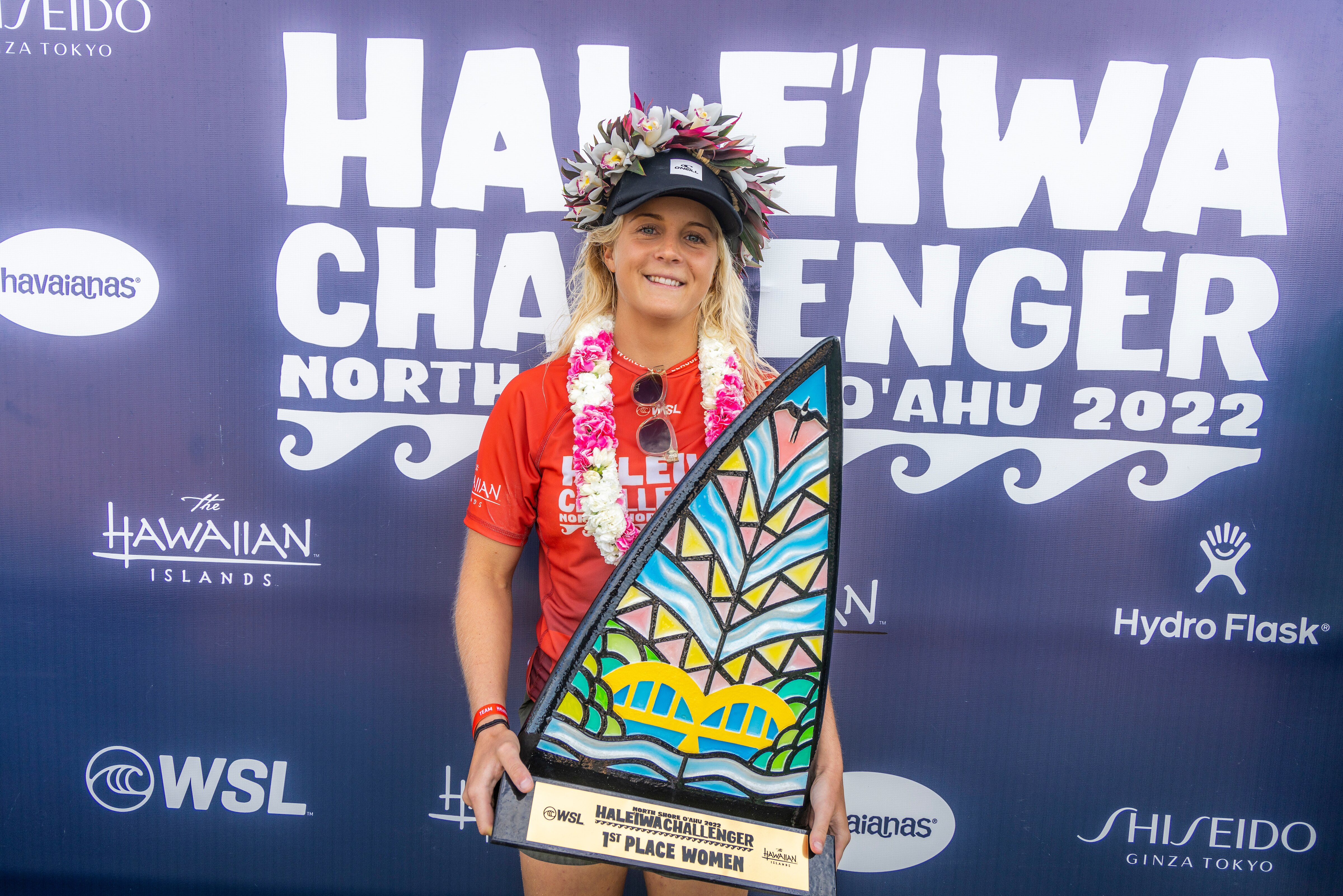 Woman in flower crown holding trophy smiling
