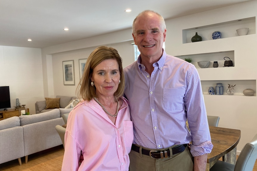 Mrs and Mr Corbett standing together in a living room. 