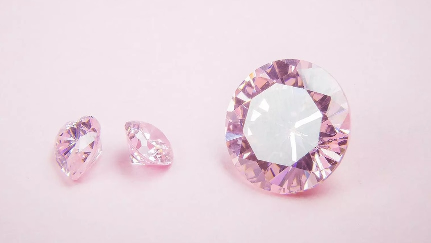 Three pink diamonds sitting against pink background