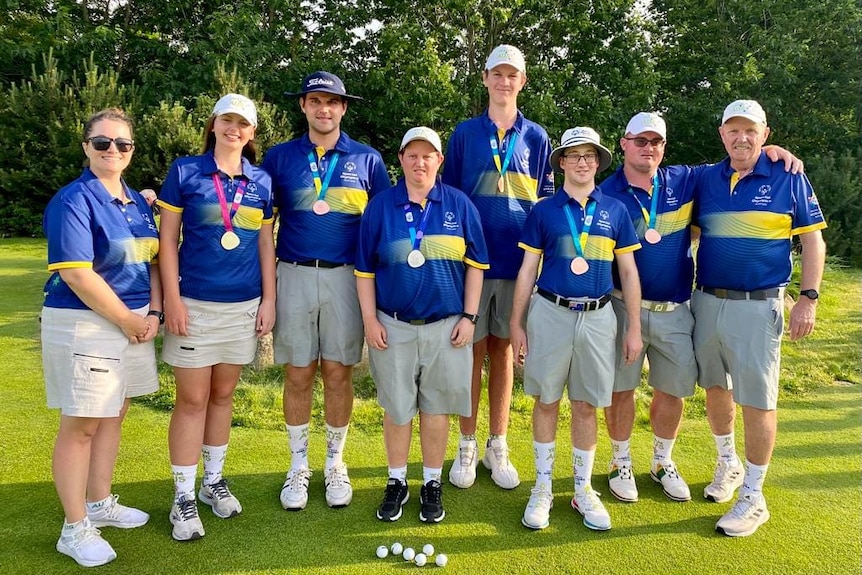 An Australian golf team at the Special Olympics World Games stand together for a group shot at the end of competition.