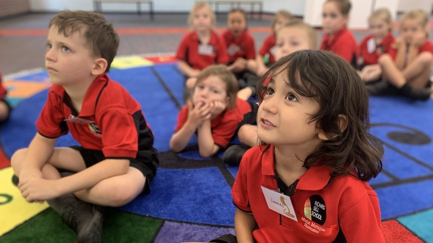 Students in class sitting on the floor at the Richard Gill School