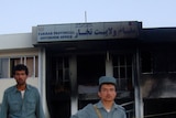 Afghan policemen guard a governor's office which was targeted by a suicide bomber