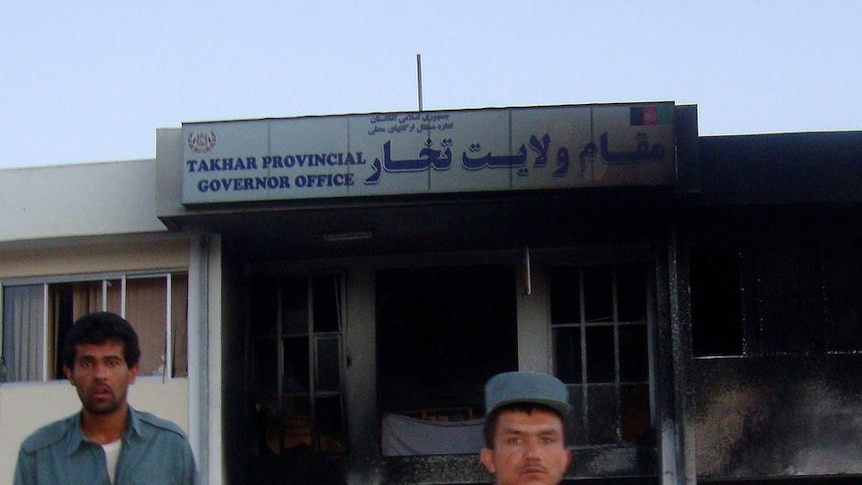 Afghan policemen guard a governor's office which was targeted by a suicide bomber