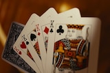 Playing cards fanned out, featuring a 'four-of-a-kind' King of hearts, spades, diamonds and clubs.