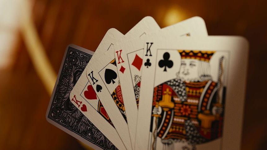Playing cards fanned out, featuring a 'four-of-a-kind' King of hearts, spades, diamonds and clubs.