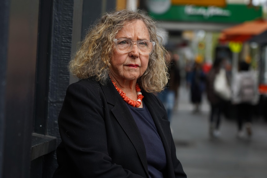 Beth Heinrich stands on a Melbourne street, looking seriously at the camera.