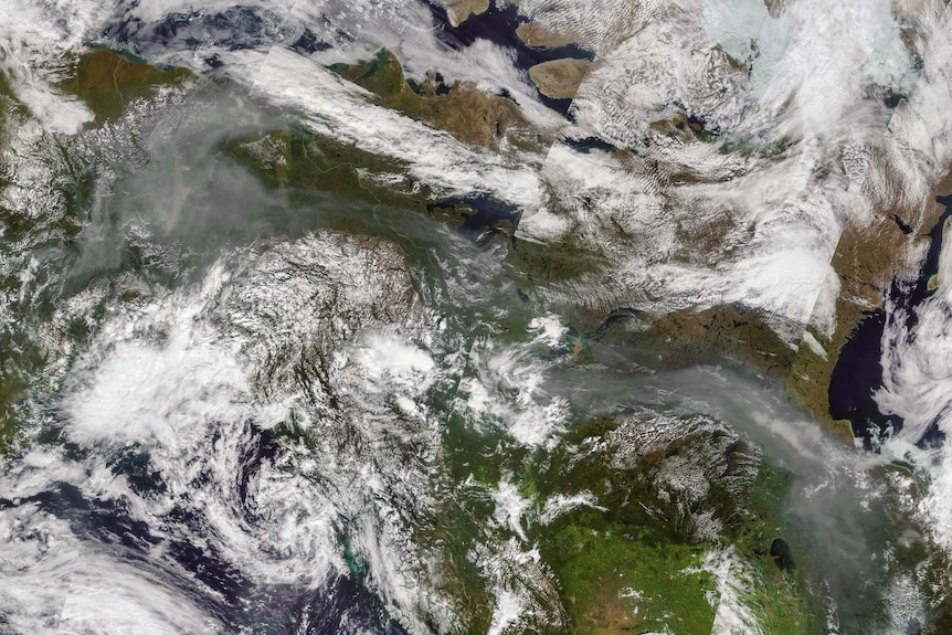 Almost a continuous string of wildfire smoke from Alaska over Canada shown on a satellite image.