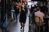A woman is seen wearing a face mask as she walks