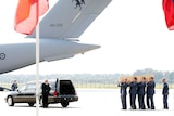 Men carry a coffin containing human remains collected at the MH17 crash site in Ukraine.