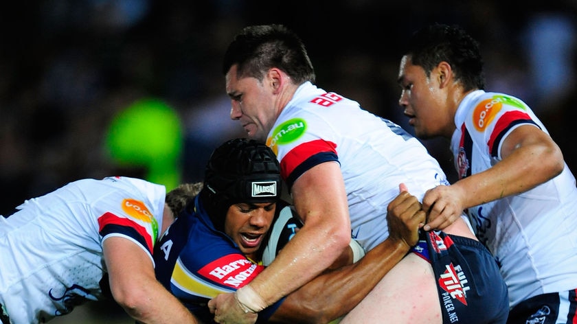 Rough send-off...departing Cowboy Ty Williams is wrapped up by the Roosters defence.