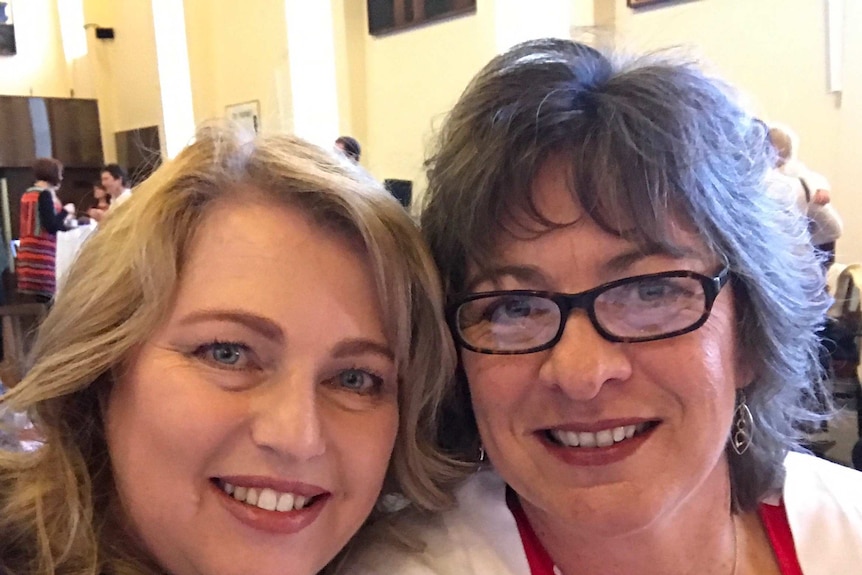 Two women, Glenda and Jennifer, smile at the camera at a public function.