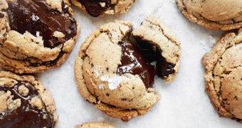 A close up of a freshly baked chocolate chip cookies with melted chocolate, illustrating our recipe.